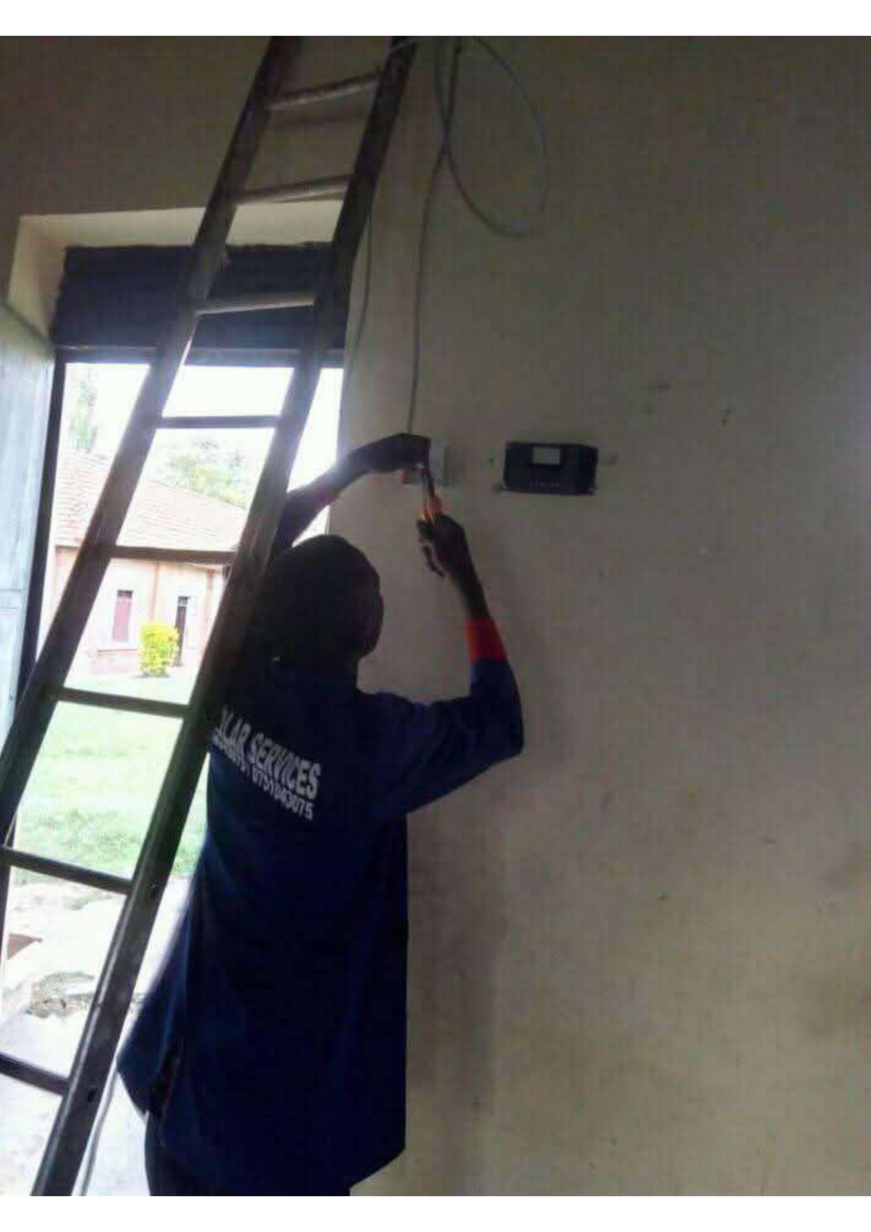 Electrician fixing a light switch at school